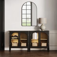 a black and gold sideboard with baskets under a mirror