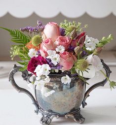 a vase filled with lots of flowers on top of a table