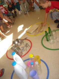 a young boy is playing with toys on the floor in front of other children and adults