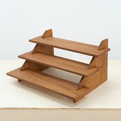 three tiered wooden display stand sitting on top of a table