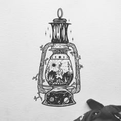 an ink drawing of a lantern with a skull in it's mouth and stars on the side