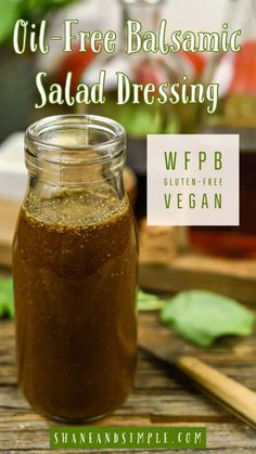 a jar filled with salad dressing sitting on top of a wooden table