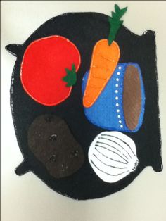 a black plate topped with vegetables on top of a white table cloth covered in felt