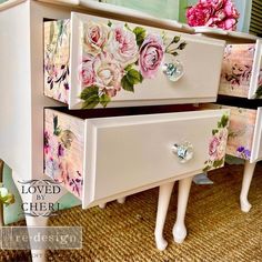 two drawers with flowers painted on them are sitting side by side in front of a mirror