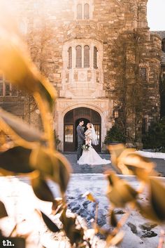 a bride and groom standing in front of a castle