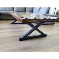 a wooden table sitting in front of a couch on top of a hard wood floor