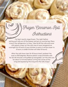 a box filled with cinnamon rolls on top of a wooden table next to a sign