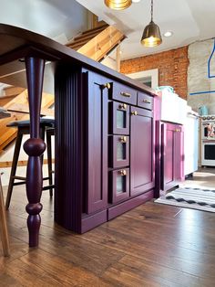 a kitchen with wooden floors and purple cabinets