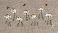 some white and yellow flowers on a tan background with a black spot in the middle