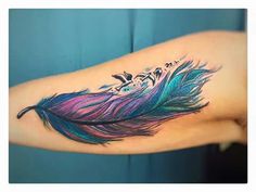 a colorful feather tattoo on the arm