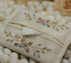 some white balls with flowers on them and a piece of cloth that has been embroidered onto it