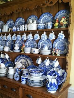 blue and white china is displayed on a shelf