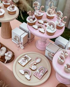 a table topped with lots of cupcakes and cakes