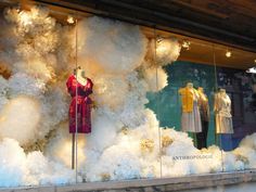 a window display with mannequins dressed in winter clothing and snow flakes