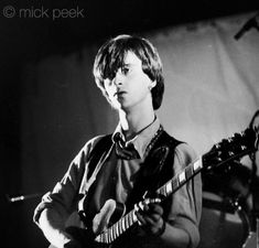 a young man playing an electric guitar on stage