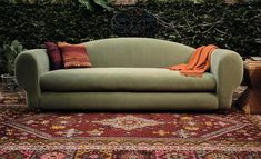 a green couch sitting on top of a rug