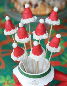 santa hats are on top of marshmallows in a cupcake like holder