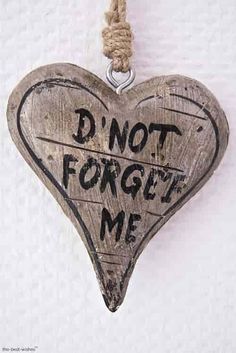 a wooden heart shaped ornament with the words don't forget me written on it