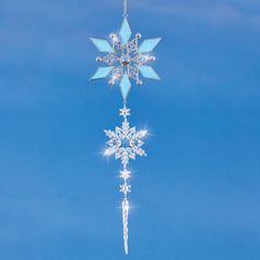 a snowflake hanging from a chain on a blue sky