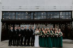 a group of people standing next to each other in front of a building with lights