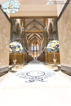 an entrance to a large building with flowers in vases on the floor and walls