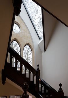 an arched window is seen from the top of a stair case in a large building