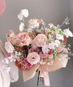 a woman wearing a pink hat holding a bouquet of flowers