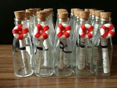 six wine bottles with red and white ribbons in them on a wooden table next to each other