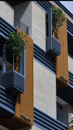 an apartment building with balconies and trees growing out of the balconies