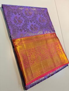 a purple and gold silk saree on display