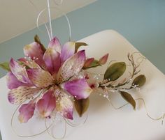 a close up of a cake with flowers on the frosting and leaves attached to it