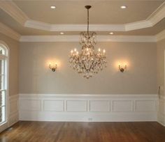 a chandelier hangs from the ceiling in an empty room