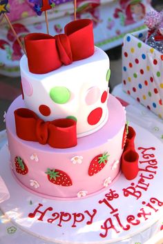 a birthday cake with strawberries and bows on it