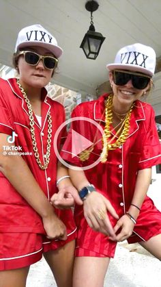 two women in matching red outfits posing for the camera with their arms around each other