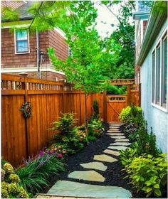 a small garden with stepping stone path leading to the front door and side of a house