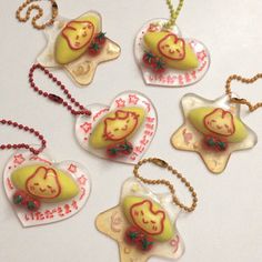 four glass ornaments are hanging from chains on a table