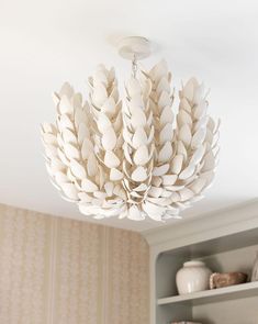 a white chandelier hanging from the ceiling in a room with bookshelves