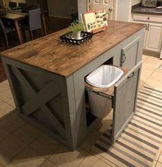 a kitchen island with a trash can underneath it