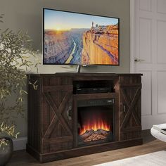 an entertainment center with a fireplace and flat screen tv