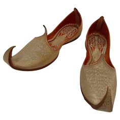 A pair of rare late 19th century hand stitched and hand tooled leather shoes with hand embroidered with gilt metallic threads. Amazing antique Mughal gold embroidered traditional Islamic Indian leather shoes fit for a Maharaja. Arabic Persian Turkish Moorish Mughal style Curled Toe Leather Shoes. These sparkly leather slippers (mojari or khussa) from India have upturned toes that are purely decorative. Embroidered with excessive amounts of gold and silver thread, with red and purple accent the slippers signify wealth, status and high fashion. Developed in the Mughal royal courts (1526–1857), this style of slipper was eventually adopted by the wealthy. They were shaped turning up This came to be very fashionable footwear. It was named after Salim, one of the sons of Jahangir (the sone of Ak Tooled Leather Shoes, Moroccan Slippers, Embroidered Slippers, Indian Shoes, Rare Shoes, Wedding Slippers, Curl Styles, Embroidered Shoes, Purple Accents