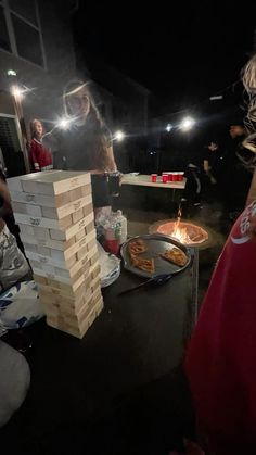 a group of people standing around a fire pit