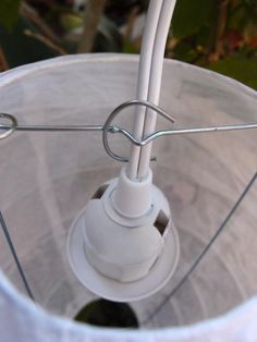 a white light fixture with wire attached to it's side and the bulb on top