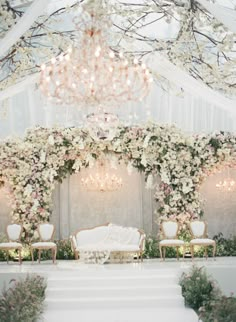 an elegant wedding setup with white flowers and chandelier