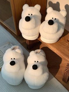 four white slippers with polar bears on them sitting next to a wooden door handle