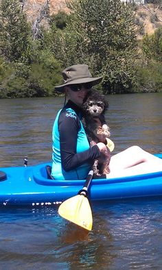 a person in a kayak with a dog on their lap