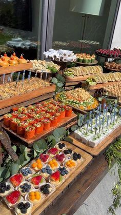 a table filled with lots of different types of food on top of wooden trays