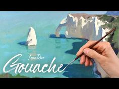 someone is holding a paintbrush in their hand and painting the landscape with watercolors