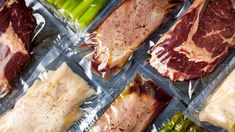 several trays filled with meat and asparagus