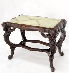 an ornate wooden bench with marble top