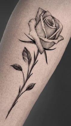 a black and white rose tattoo on the arm